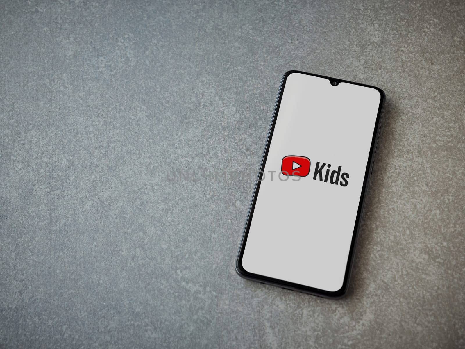 Lod, Israel - July 16,2023: YouTube Kids app launch screen on smartphone on ceramic stone background. Top view flat lay with copy space.