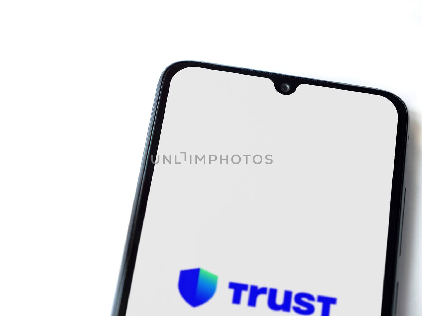 Lod, Israel - July 16,2023: Trust Wallet app launch screen on smartphone on white background. Top view flat lay with copy space.