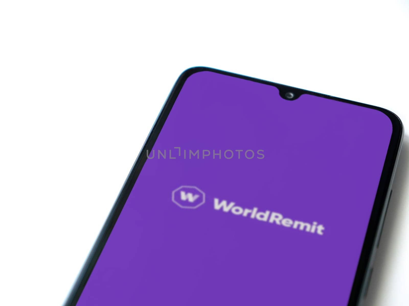 Lod, Israel - July 16,2023: WorldRemit app launch screen on smartphone on white background. Top view flat lay with copy space.