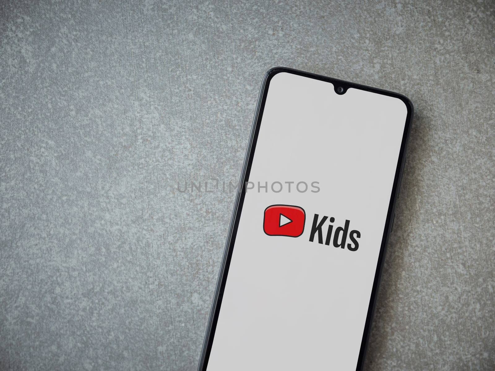 Lod, Israel - July 16,2023: YouTube Kids app launch screen on smartphone on ceramic stone background. Top view flat lay with copy space.