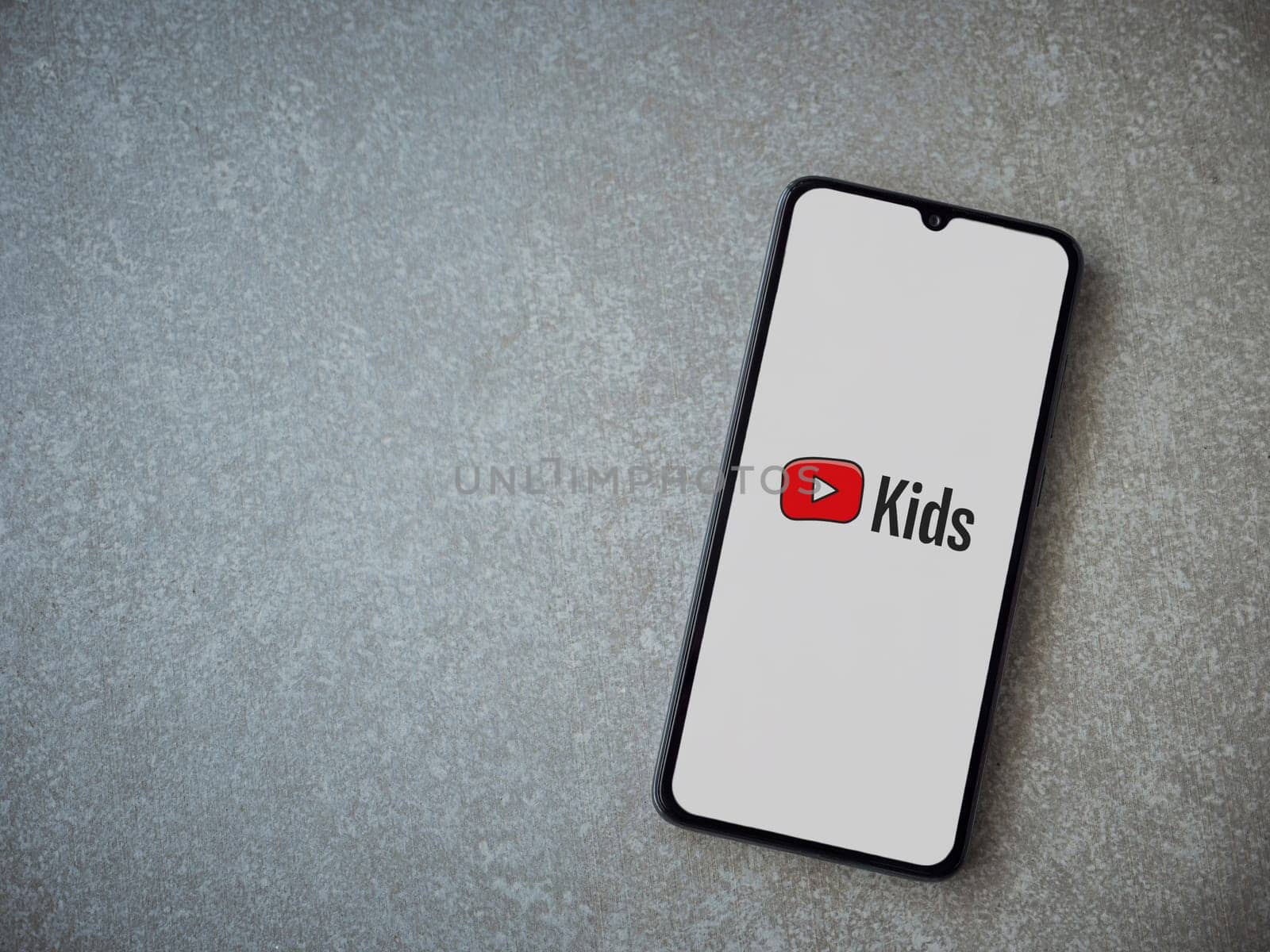 Lod, Israel - July 16,2023: YouTube Kids app launch screen on smartphone on ceramic stone background. Top view flat lay with copy space.