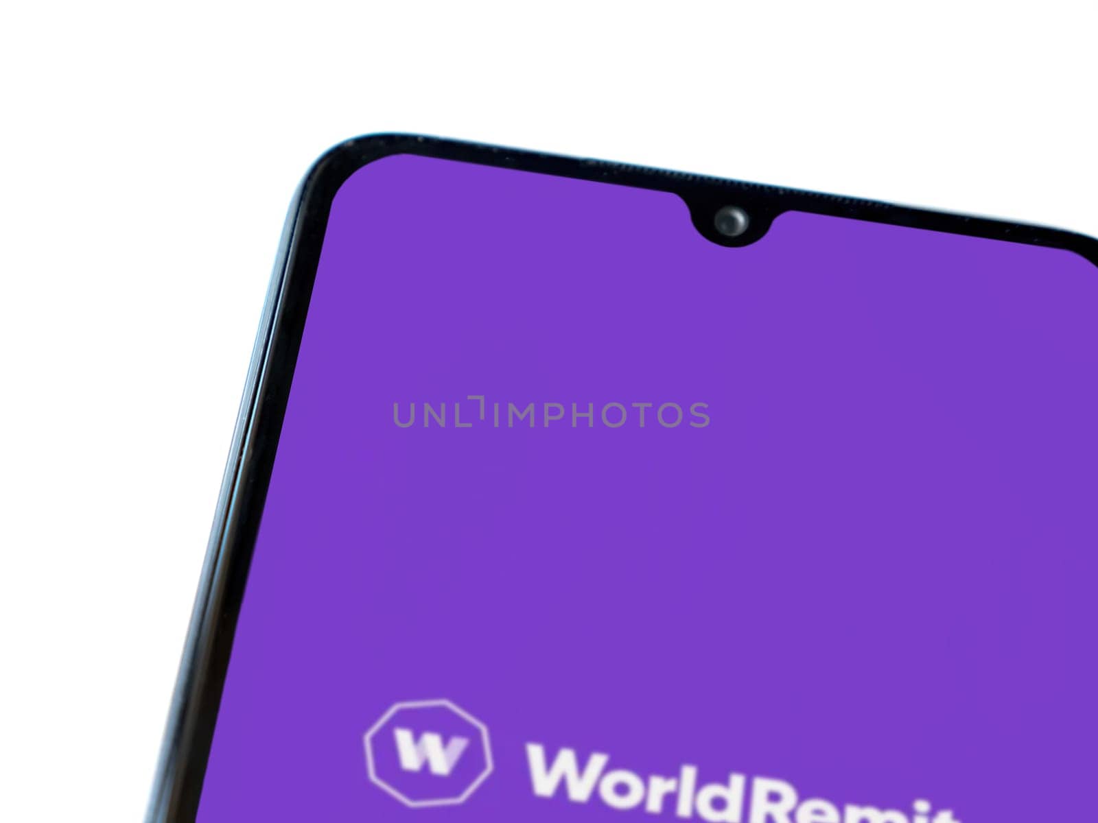 Lod, Israel - July 16,2023: WorldRemit app launch screen on smartphone on white background. Top view flat lay with copy space.