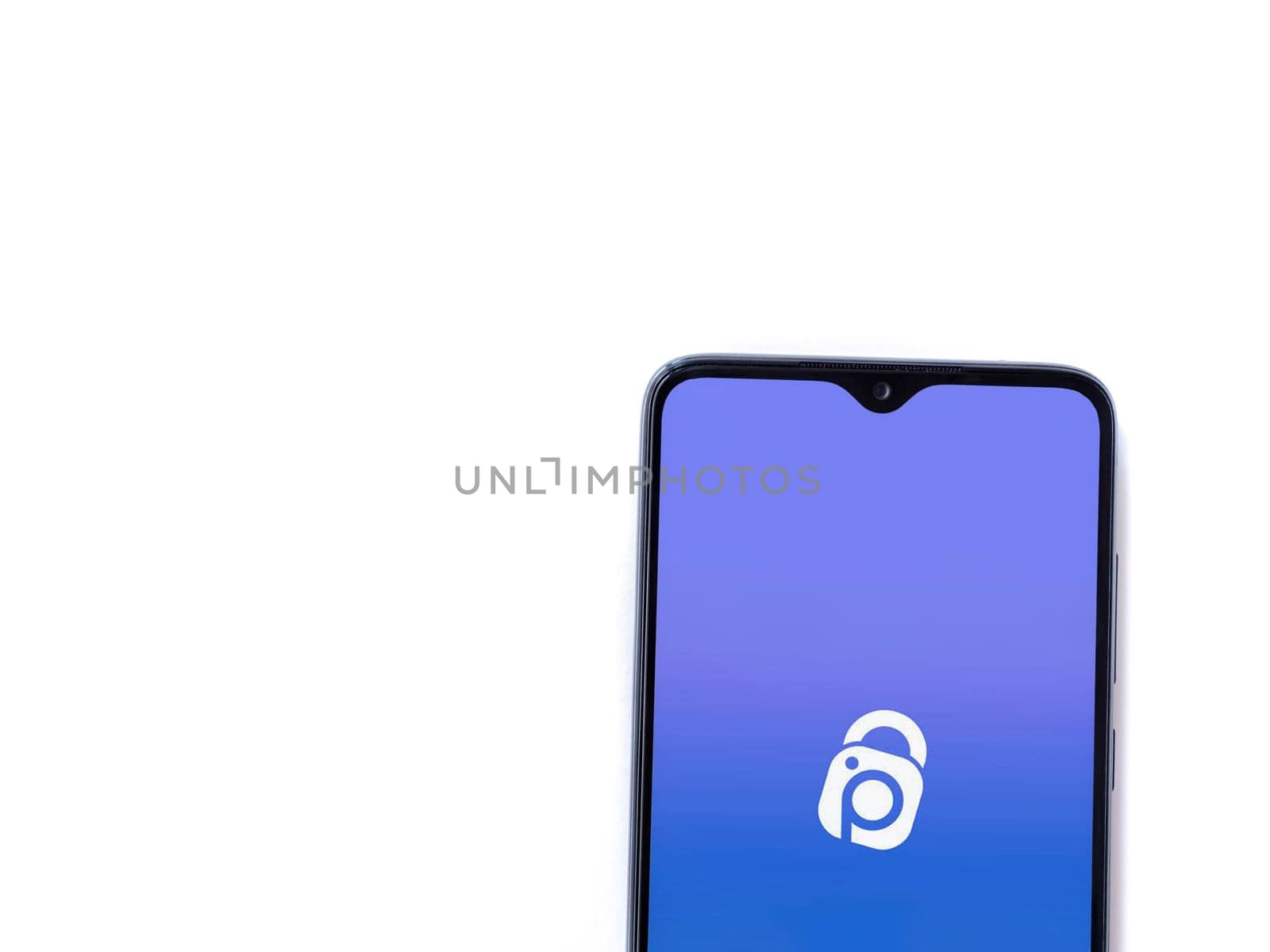 Lod, Israel - July 16,2023: IDrive Photo Backup app launch screen on smartphone on white background. Top view flat lay with copy space.