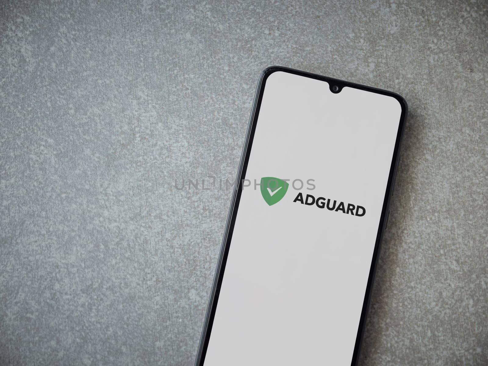 Lod, Israel - July 16,2023: AdGuard app launch screen on smartphone on ceramic stone background. Top view flat lay with copy space.
