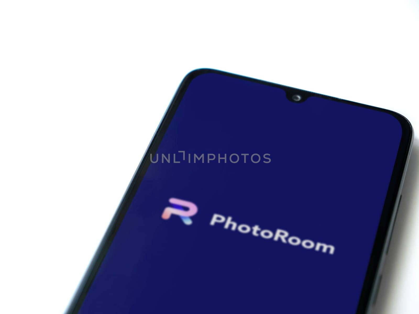 Lod, Israel - July 16,2023: PhotoRoom Studio Photo Editor app launch screen on smartphone on white background.. Top view flat lay with copy space.