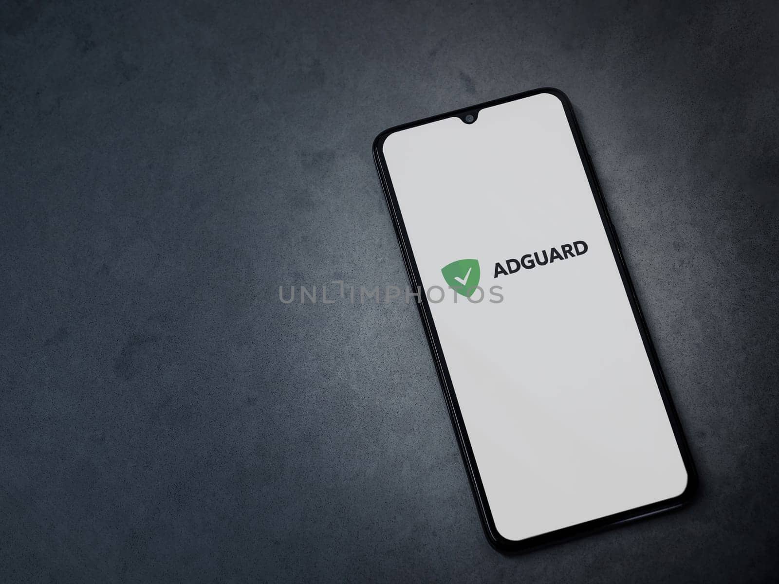 Lod, Israel - July 16,2023: AdGuard app launch screen on smartphone on dark marble stone background. Top view flat lay with copy space.