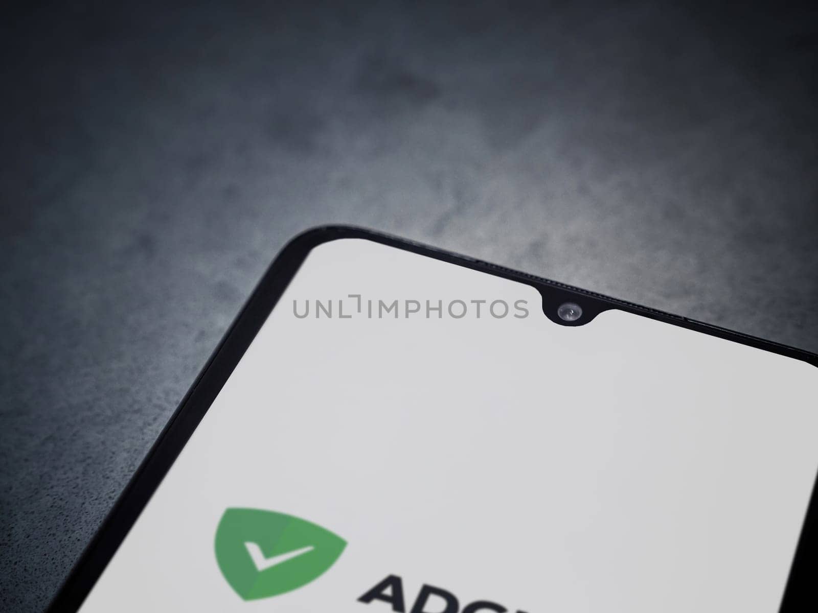 Lod, Israel - July 16,2023: AdGuard app launch screen on smartphone on dark marble stone background. Top view flat lay with copy space.