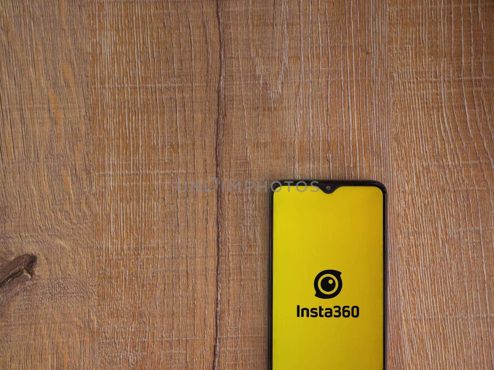 Lod, Israel - July 16,2023: Insta360 app launch screen on smartphone on wooden background.. Top view flat lay with copy space.