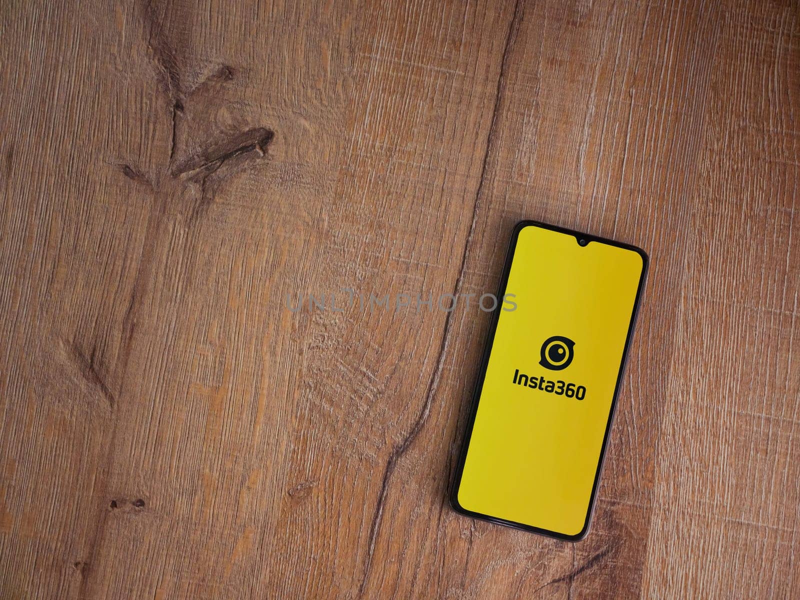 Lod, Israel - July 16,2023: Insta360 app launch screen on smartphone on wooden background.. Top view flat lay with copy space.