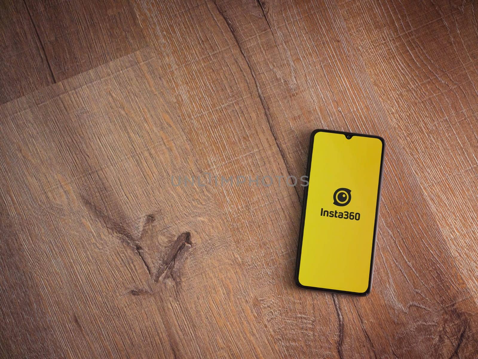 Lod, Israel - July 16,2023: Insta360 app launch screen on smartphone on wooden background. Top view flat lay with copy space.
