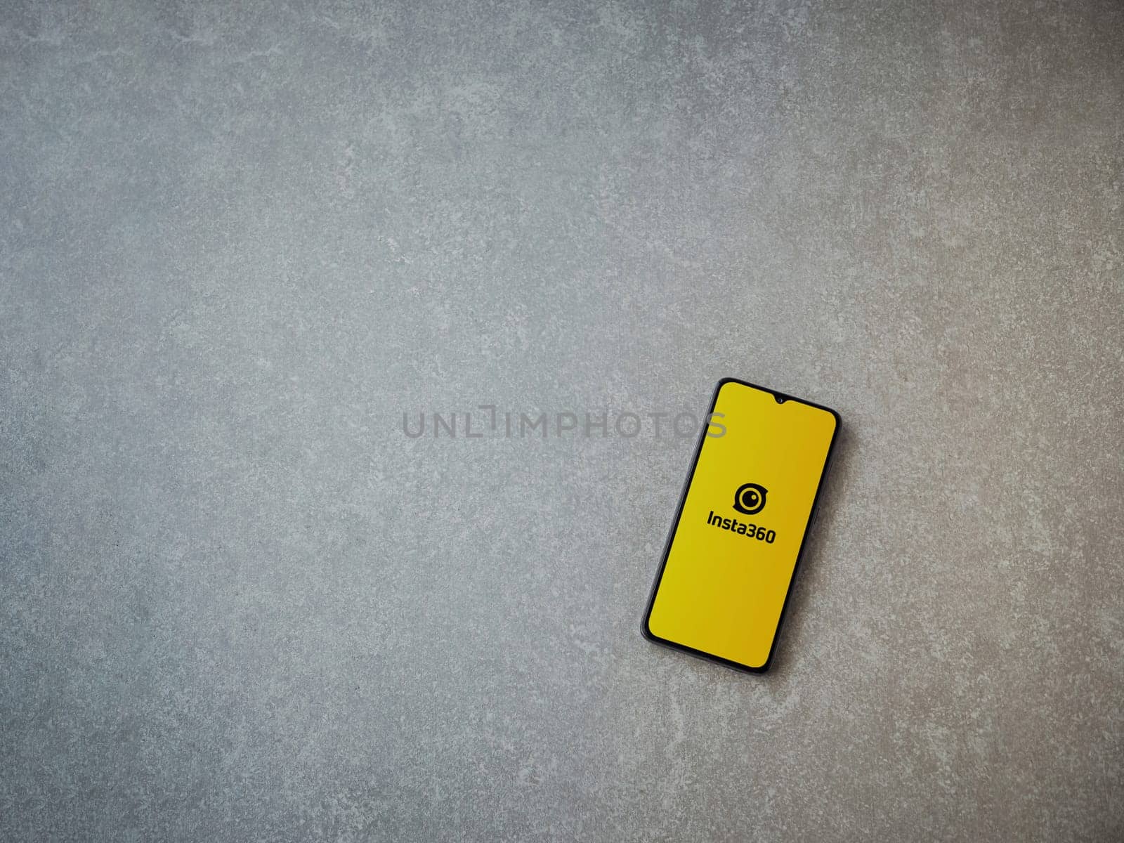 Lod, Israel - July 16,2023: Insta360 app launch screen on smartphone on ceramic stone background.. Top view flat lay with copy space.