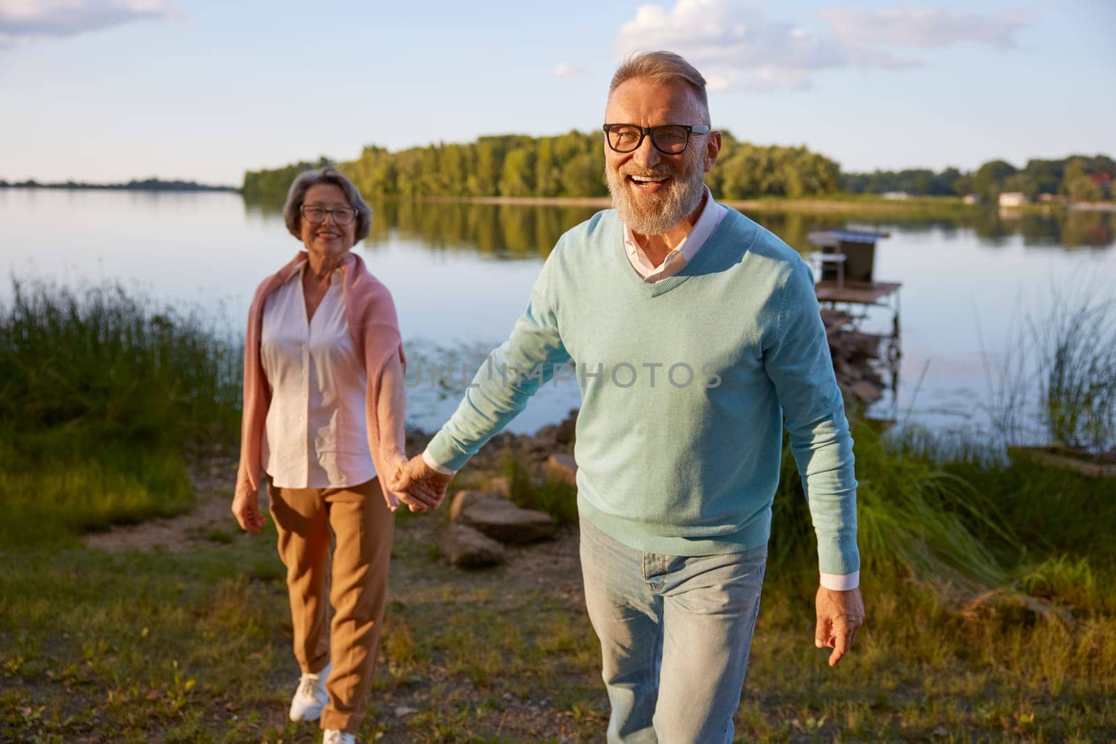 Happy shiny smiling elderly couple spending summer vacation time on nature. Relax, care, support and loving relationship until old age