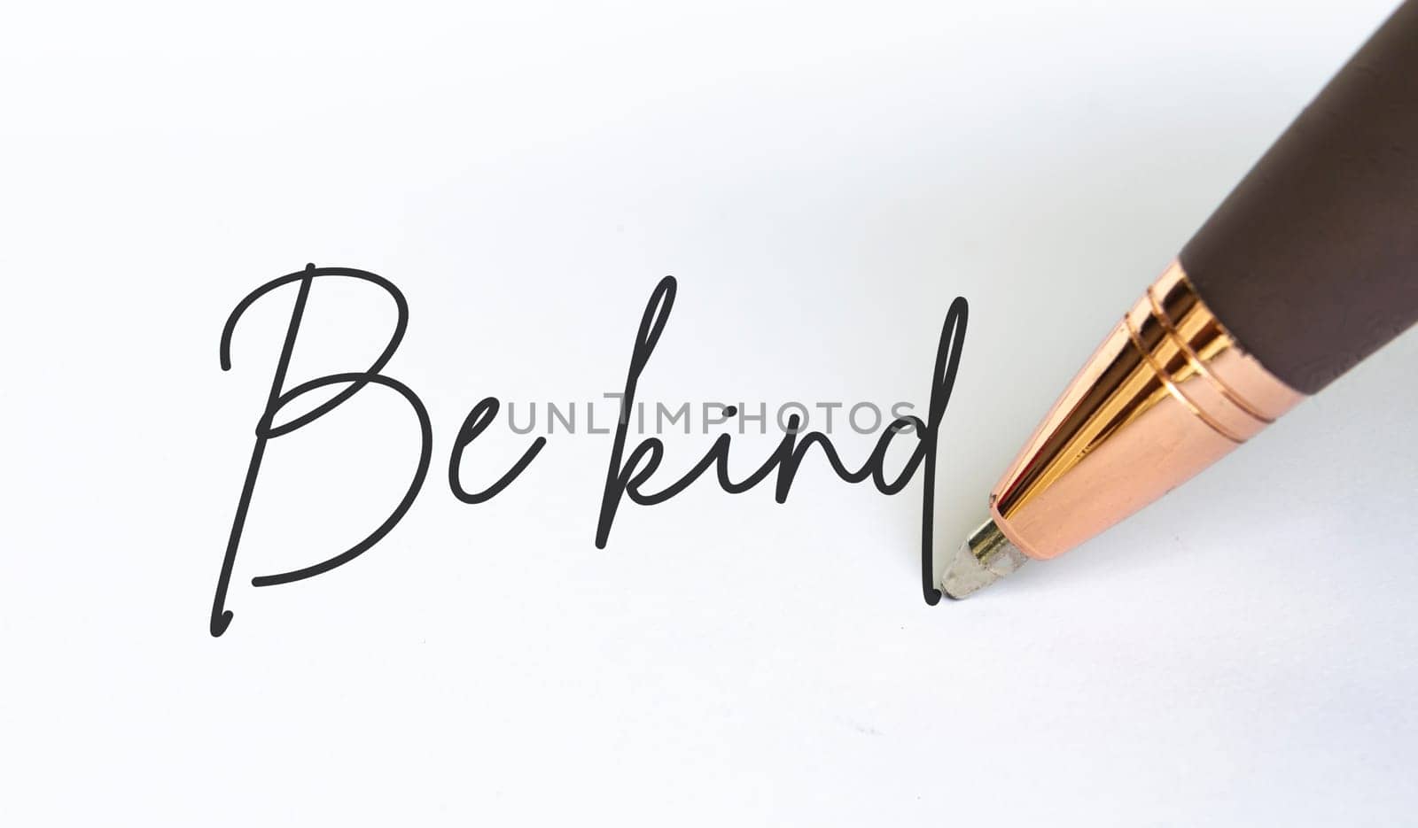 Be kind text written on white notepad.