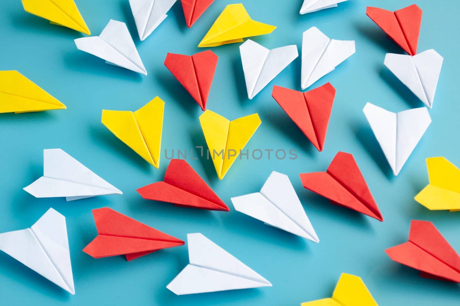 Low view of yellow paper plane origami leading white paper planes. With copy space for text