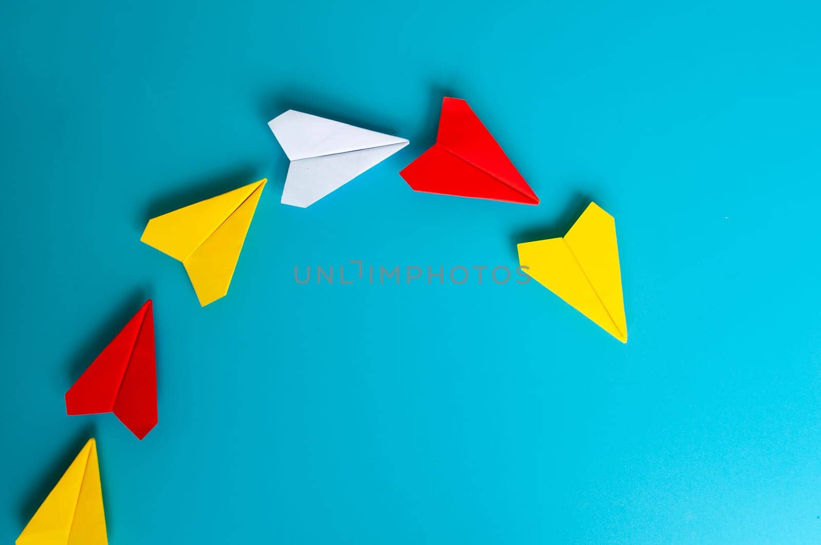 Low view of yellow paper plane origami leading white paper planes. With copy space for text