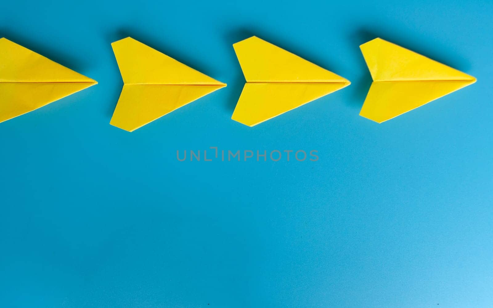 Top view of yellow paper airplanes with space for text.