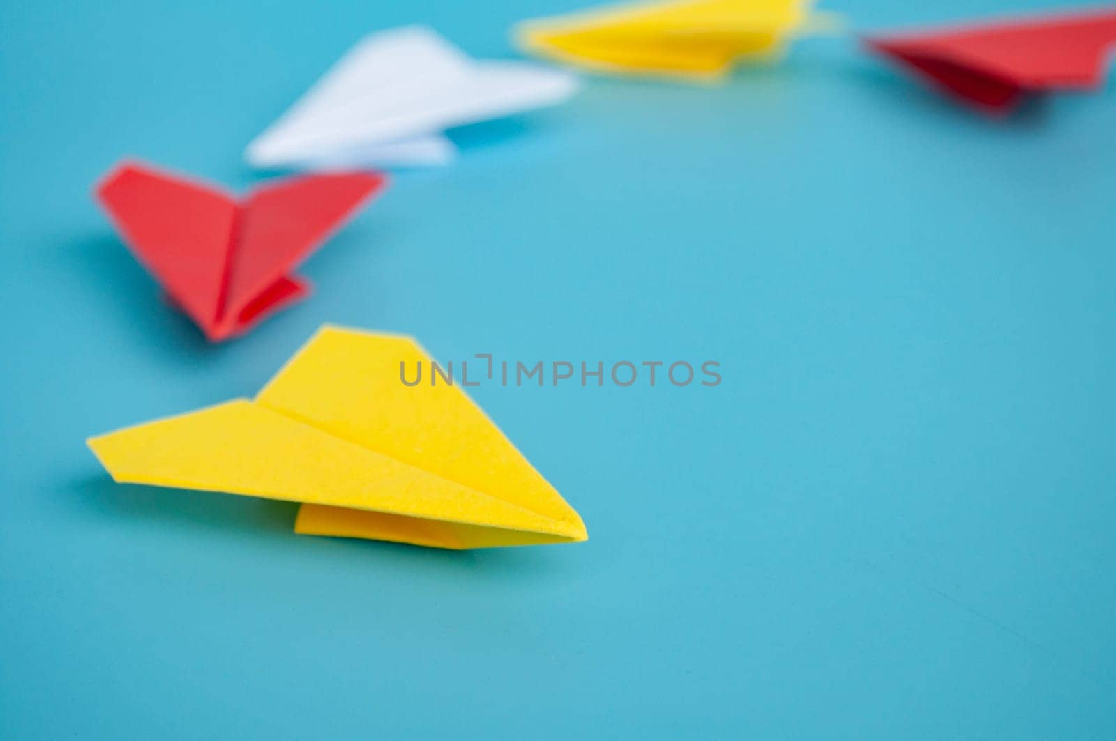 Low view of yellow paper plane origami leading white paper planes. With copy space for text