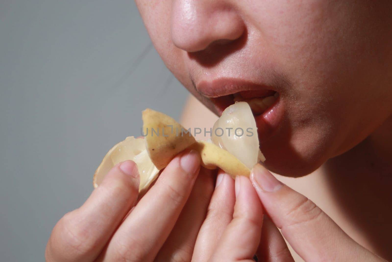 Woman eating Langsat, Longkong, is a fruit found in the forests of tropical countries in Asia. And it is a fruit with a delicious aroma that is popular in Thailand, Malaysia, Singapore, Indonesia, Laos and Vietnam