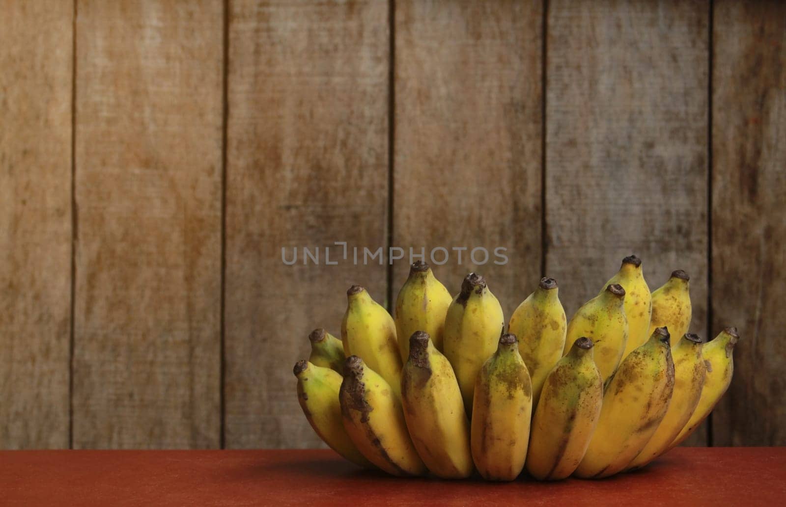 Banana fruit with wooden table on blurred background