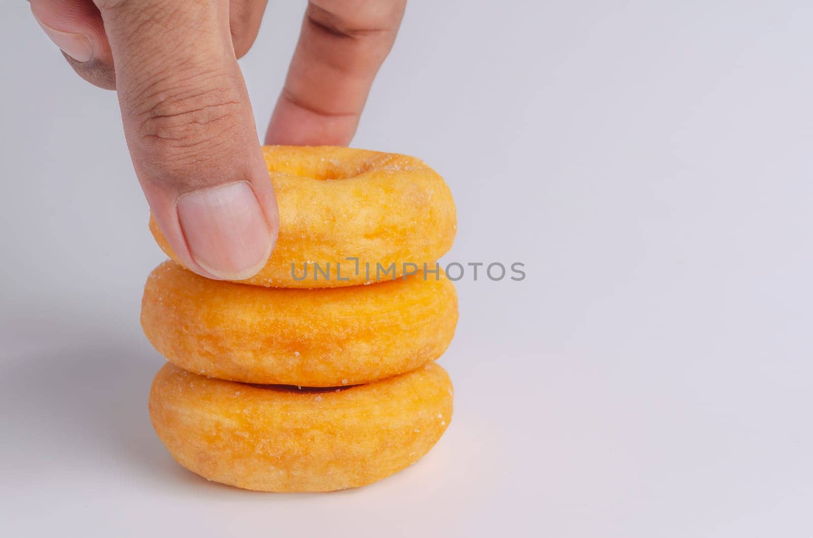 Hand with Donuts cake bakery sprinkled with sugar on white background