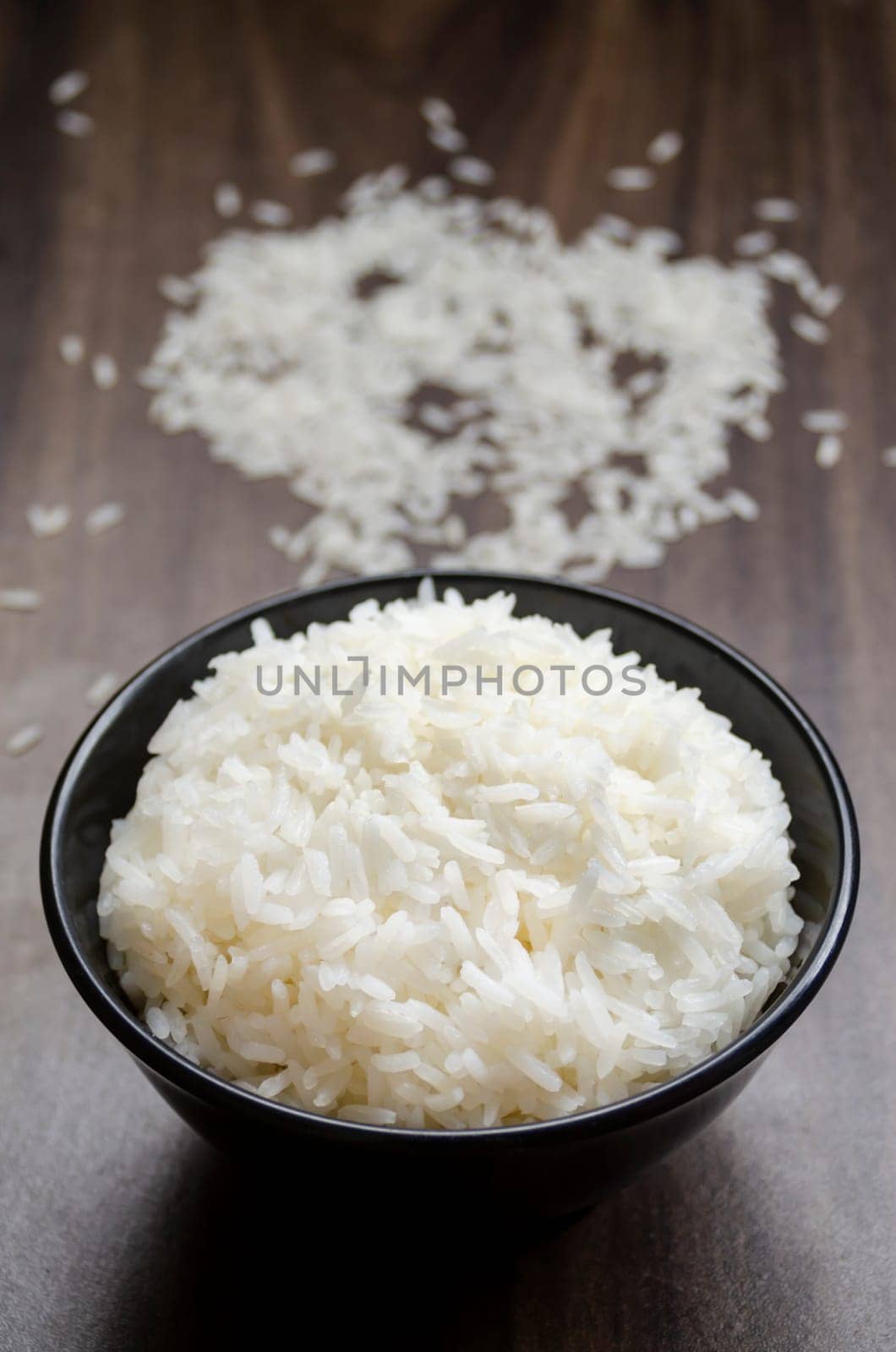Rice in cup on wooden table blurred background