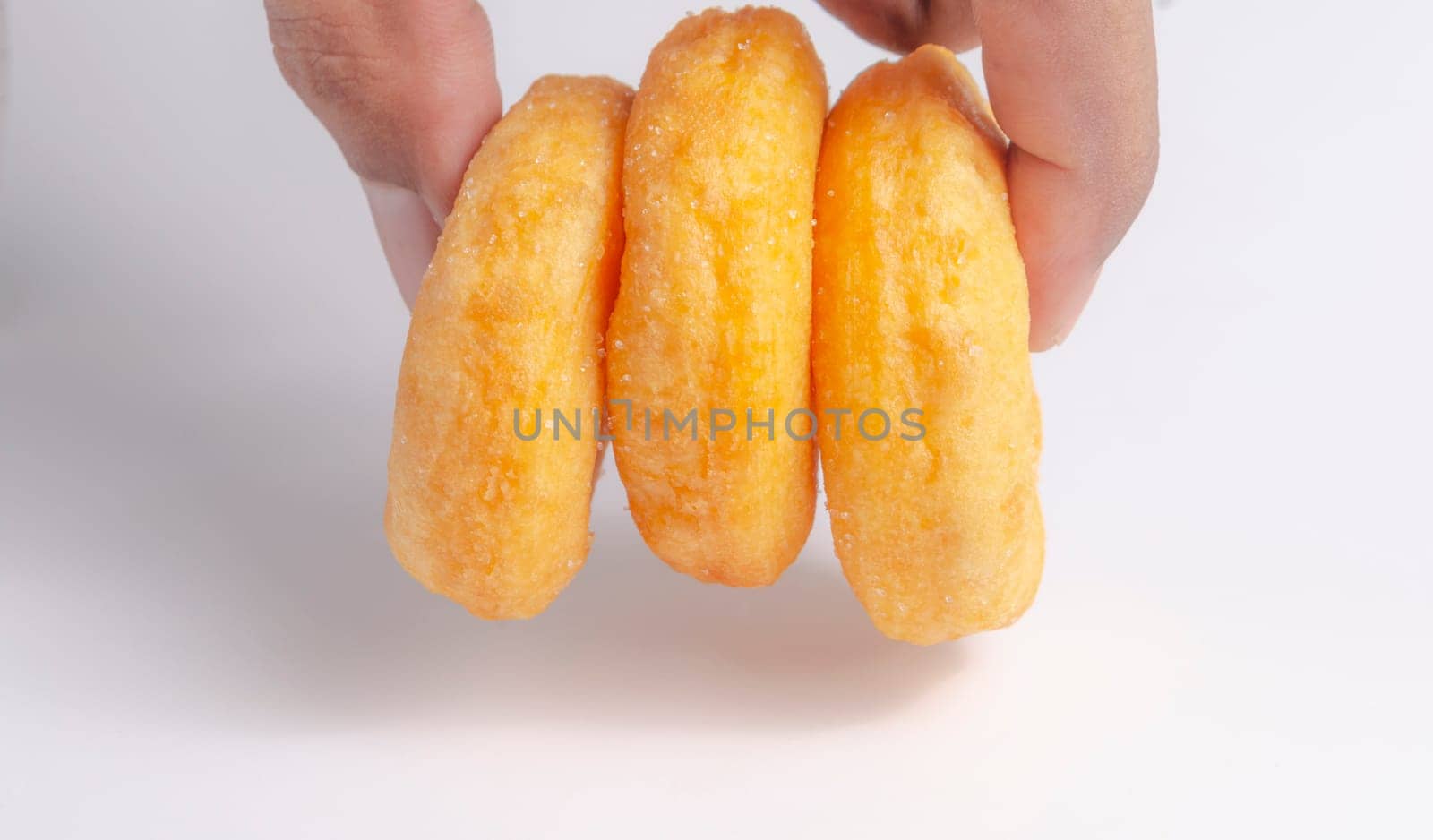 Hand with Donuts cake bakery sprinkled with sugar on white background