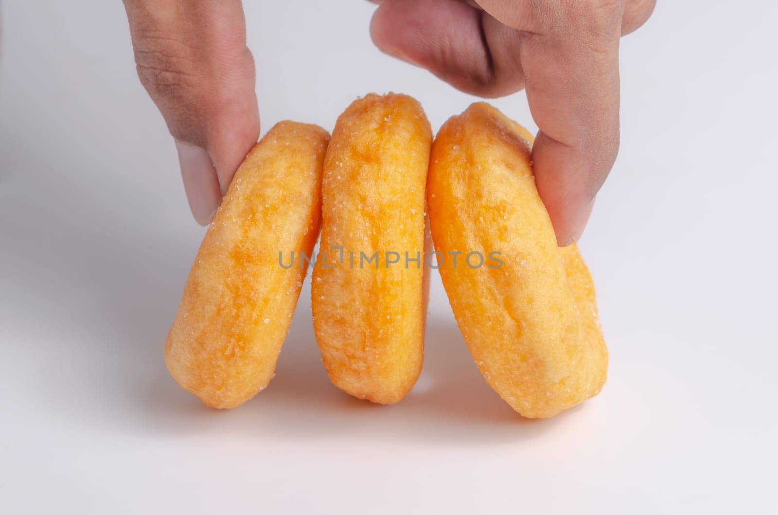 Hand with Donuts cake bakery sprinkled with sugar on white background