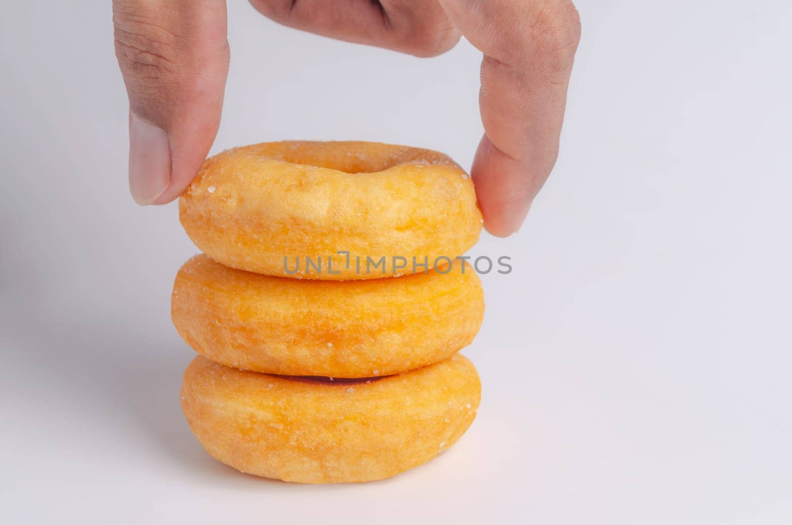 Hand with Donuts cake bakery sprinkled with sugar on white background