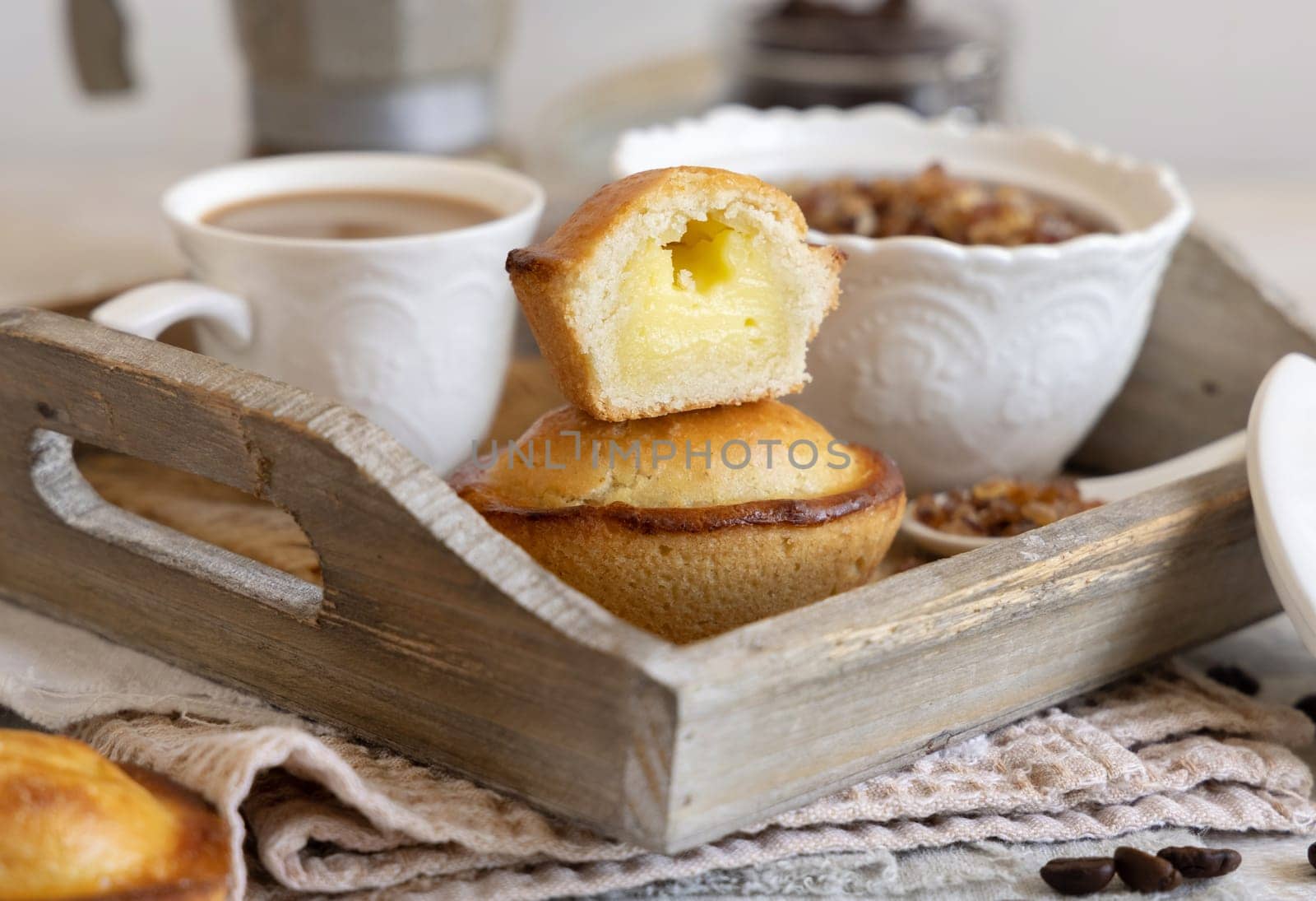 Pasticciotto leccese pastry filled with egg custard cream, typical sweet from Lecce, Italy. Pieces of pasticiotto on a wooden tray, apulian breakfast with coffee close up