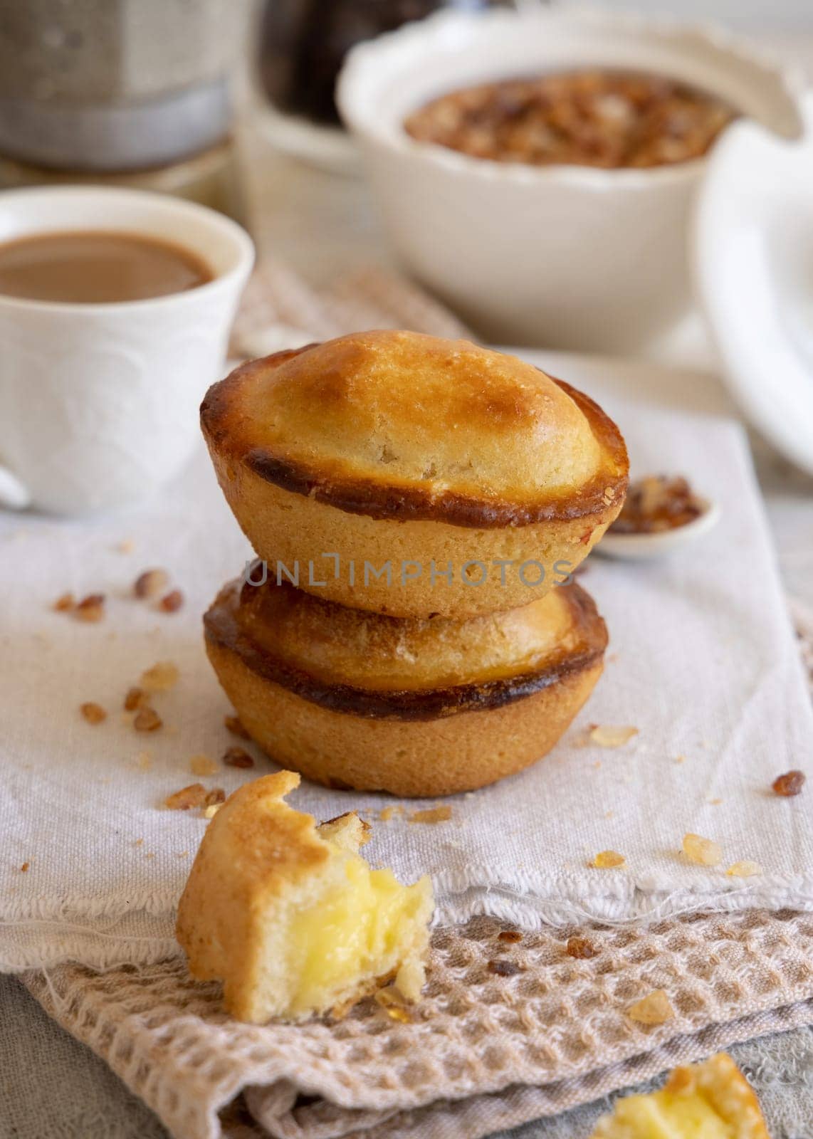 Pasticciotto leccese pastry filled with egg custard cream, typical sweet from Lecce, Italy. Pieces of pasticiotto on a beige napkin, apulian breakfast with coffee close up