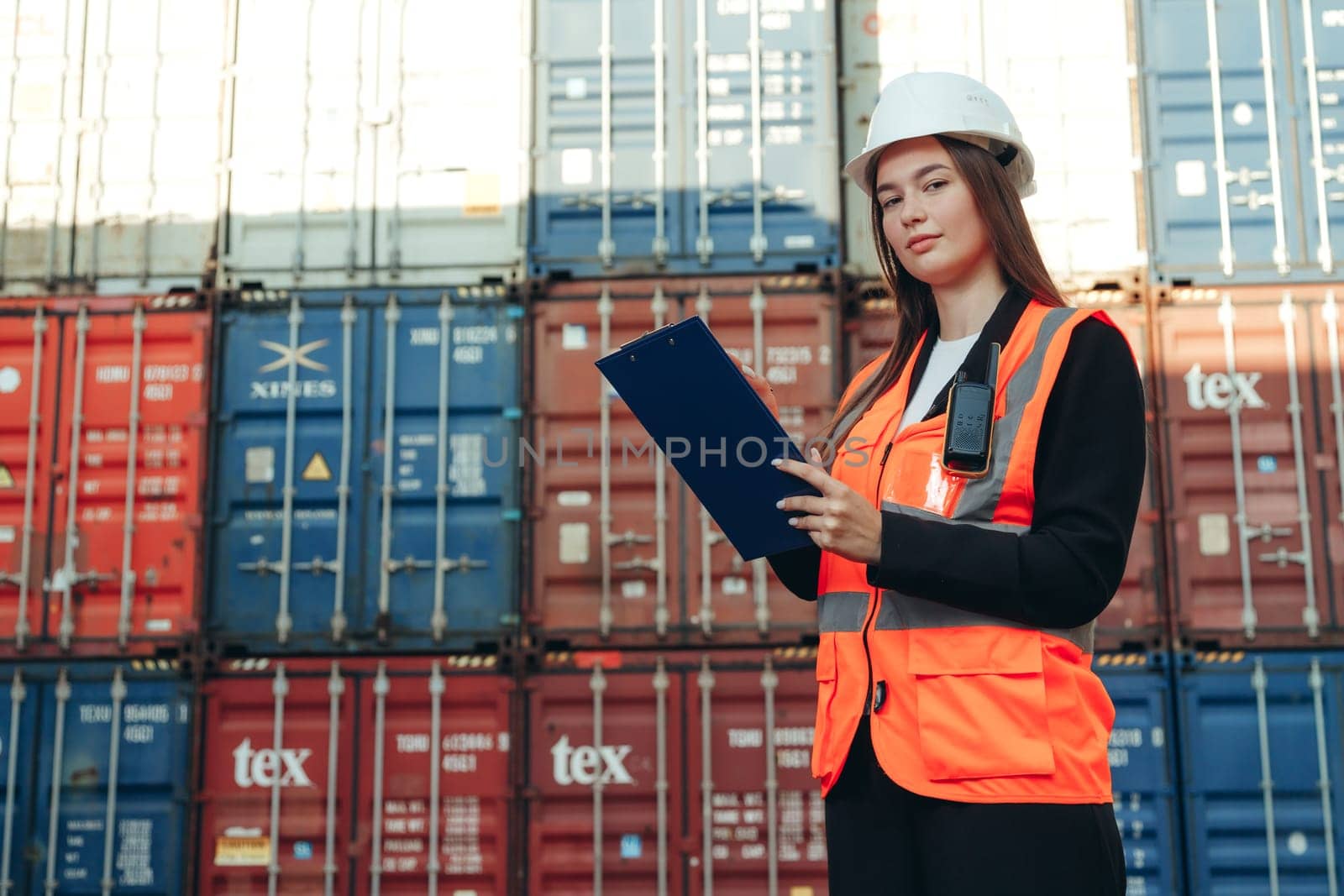 Woman Works in international shipping area Export and import delivery service with containers