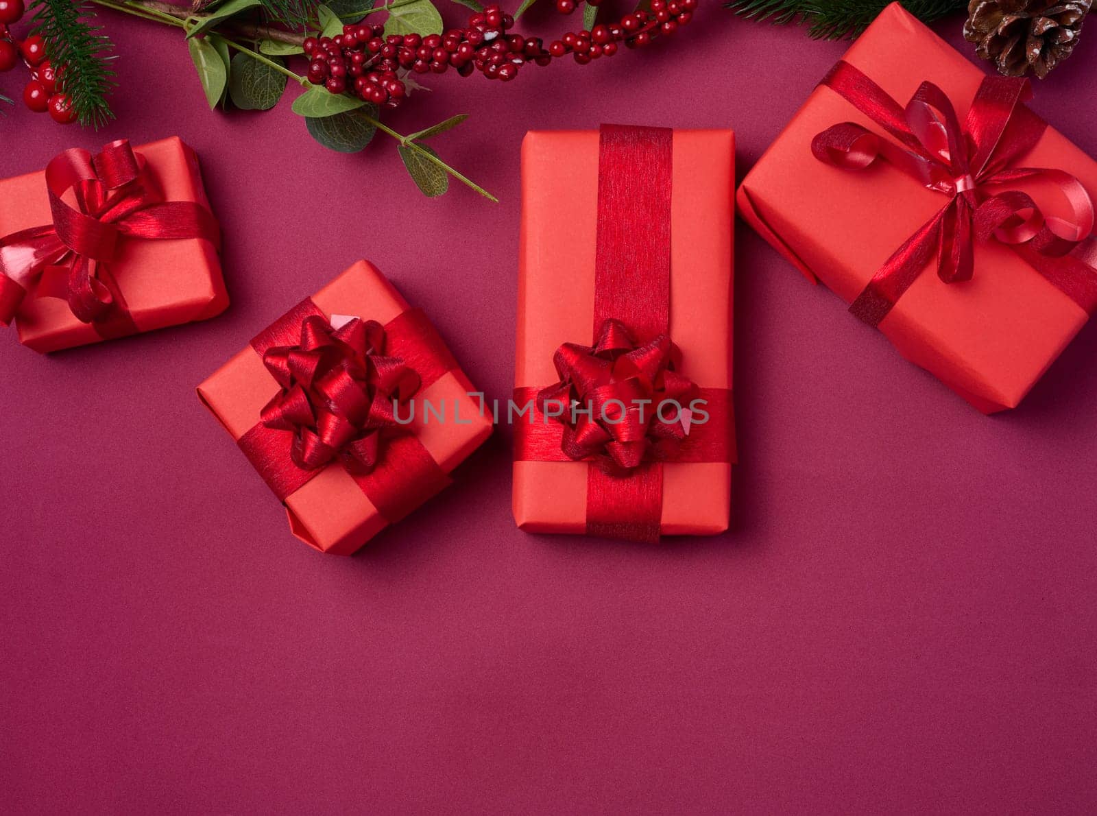 Christmas decor, gifts wrapped in red paper on a red background, top view