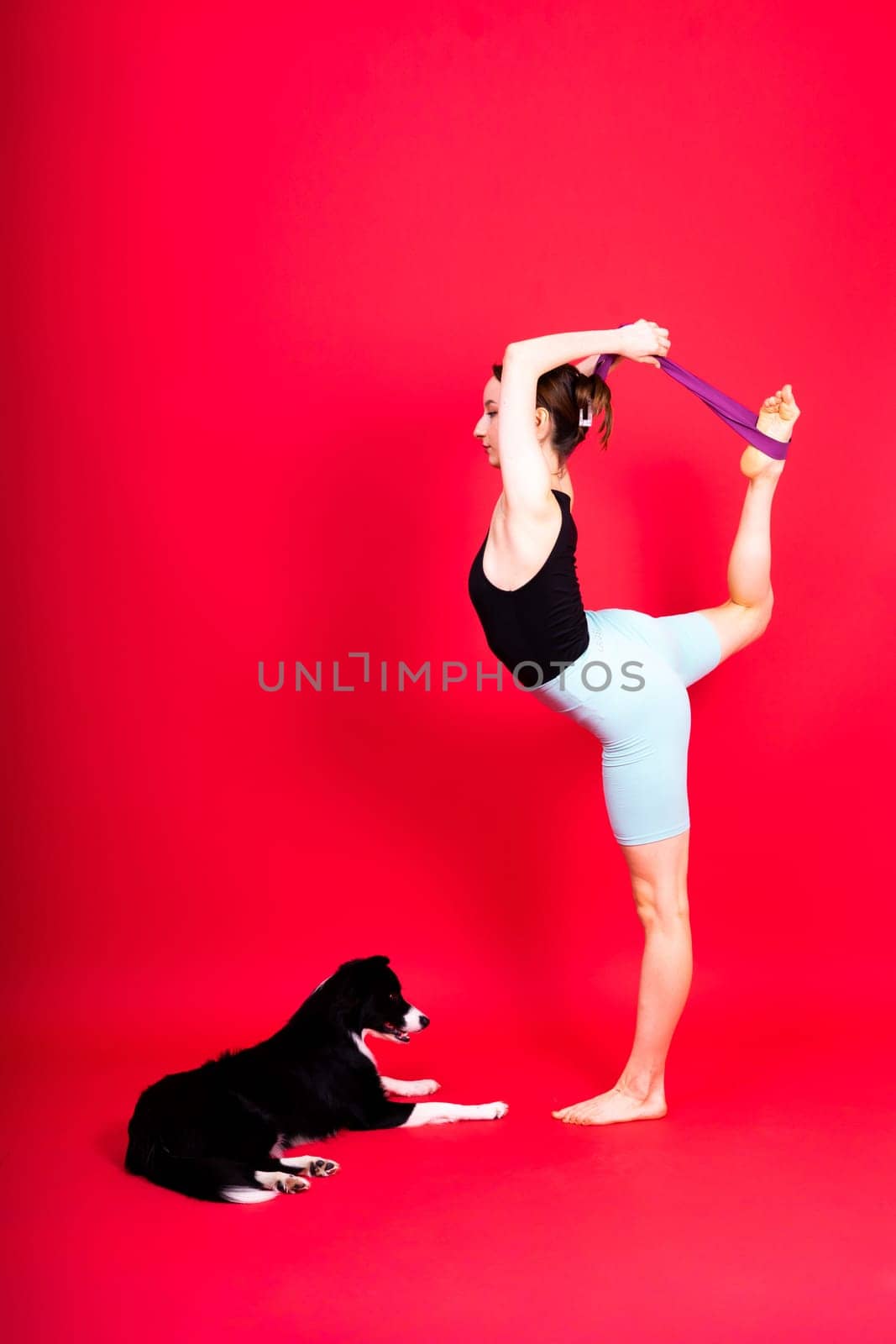 Shot of sport female in leggings with a border collie dog isolated on yellow and red background