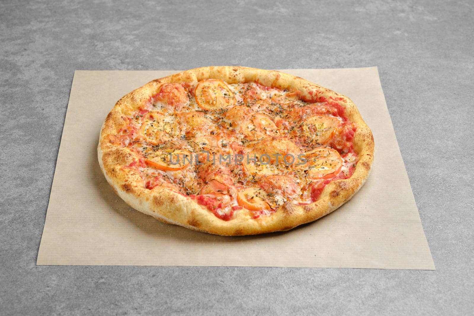 Classic pizza margherita with oregano on parchment