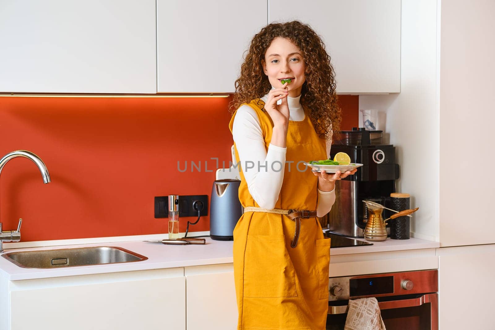 Playful woman eating spinach leaf