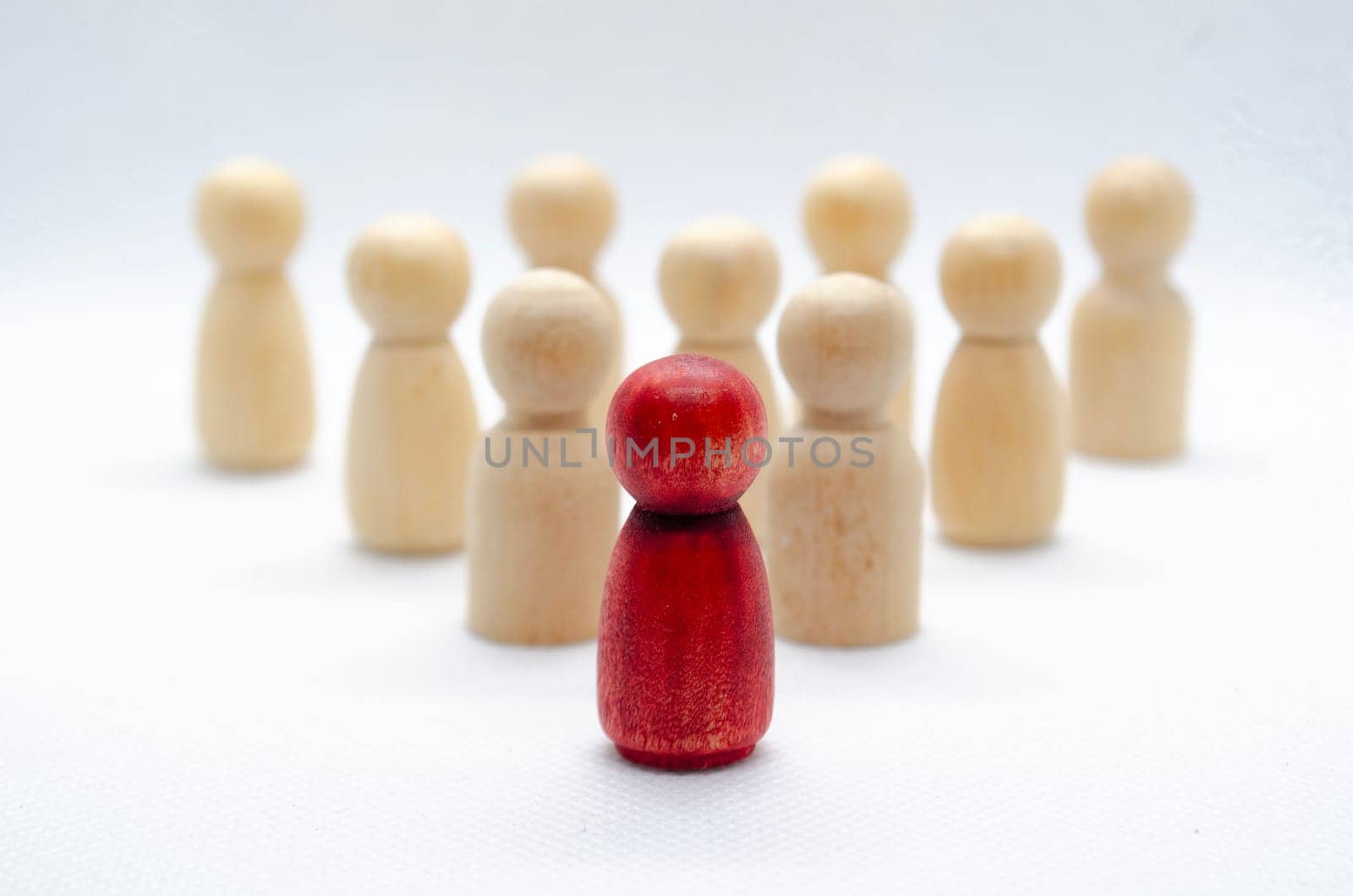 Leadership concept - red wooden figure leading other wooden figures reaching. Leadership concept.