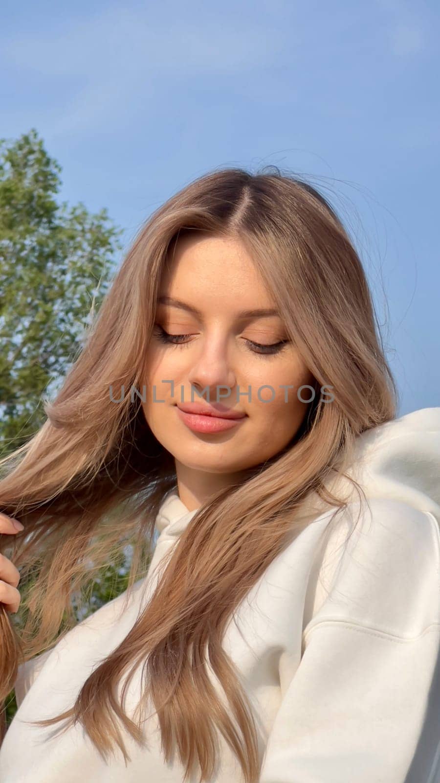 young pretty woman with straight long hair and wearing white sportswear walks with baby.