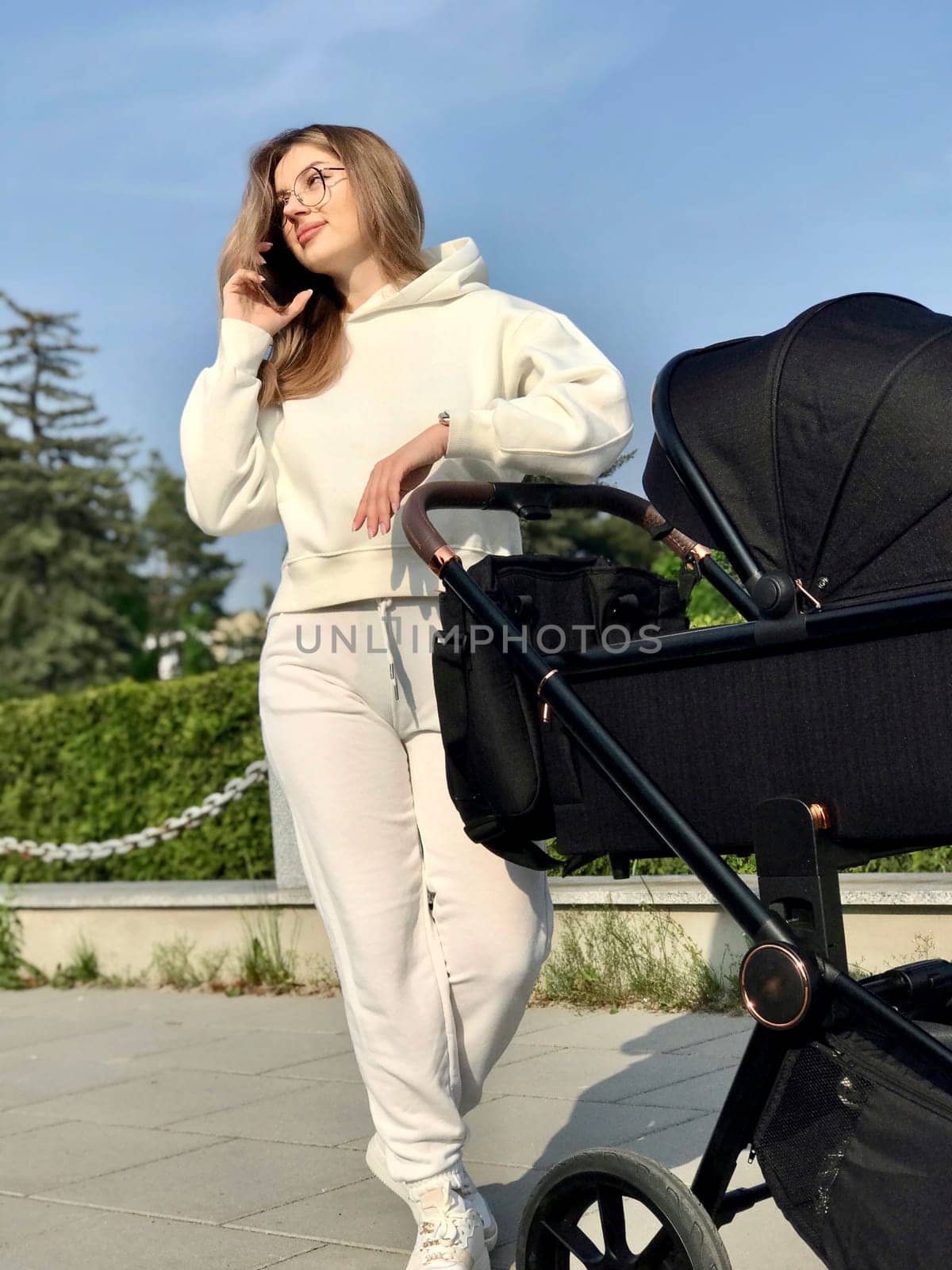 young pretty woman with straight long hair and wearing white sportswear walks with baby.