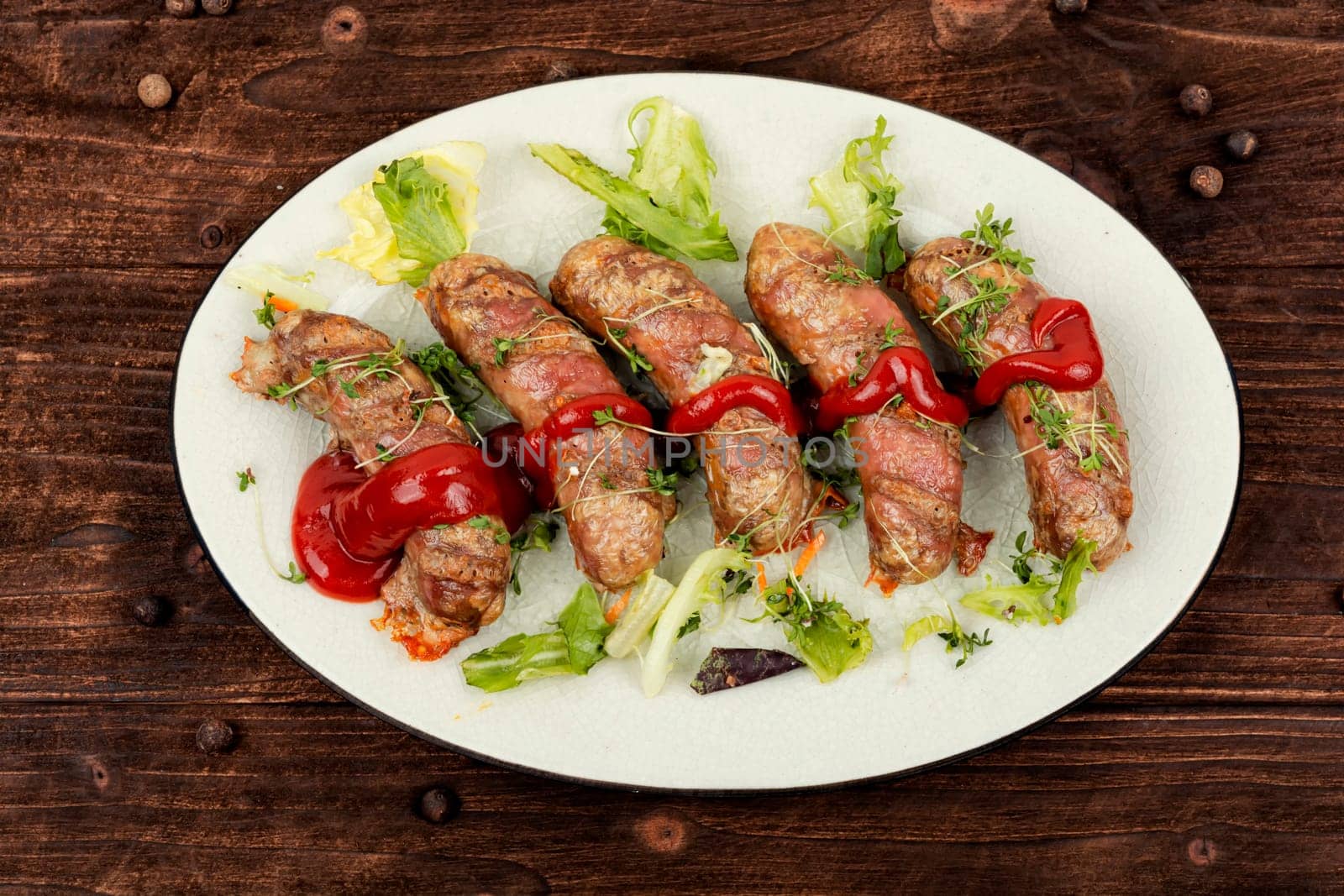 Fried sausage on plate, fast food. Barbecue bratwurst, Oktoberfest celebration.