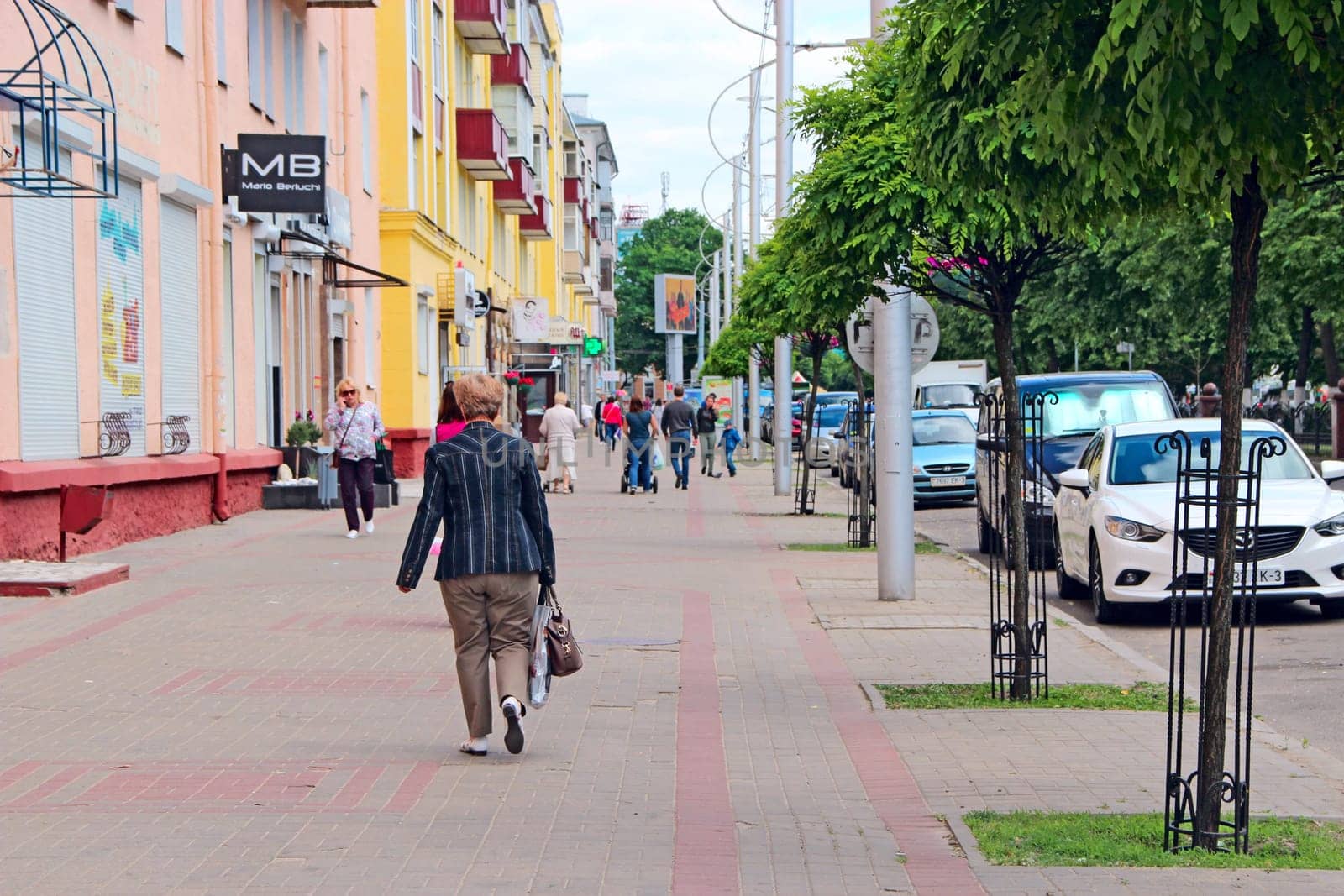 Central street of Gomel. People walking along Gomel street. Urban panorama. People walking along street of Belarusian city. Cityscape. Urban panorama
