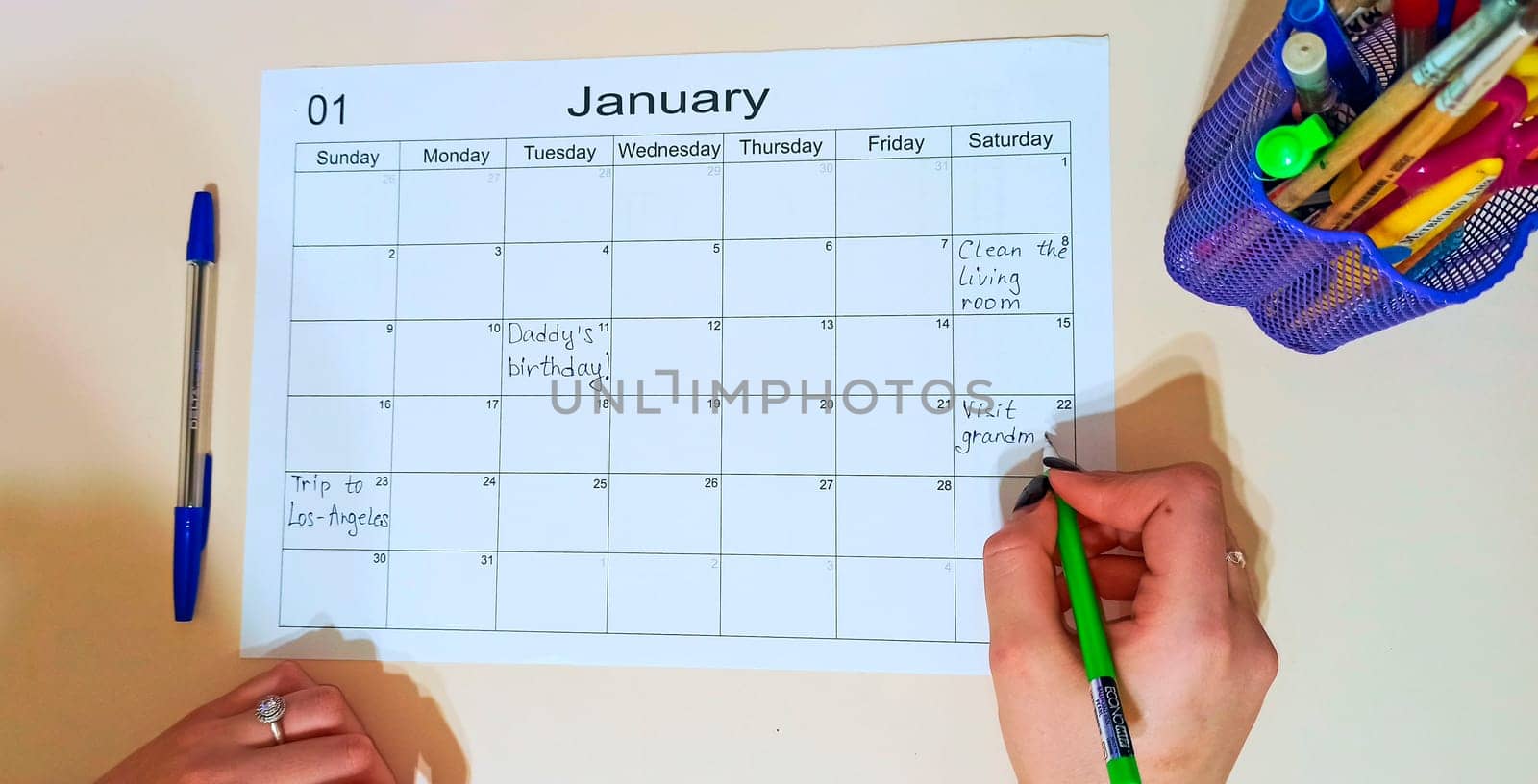 Planner for month. Calendar January. schedule with blank note for to do list on paper background. Human hand filling out to-do list for the month. Empty cells of planner. Monthly organizer. To do list
