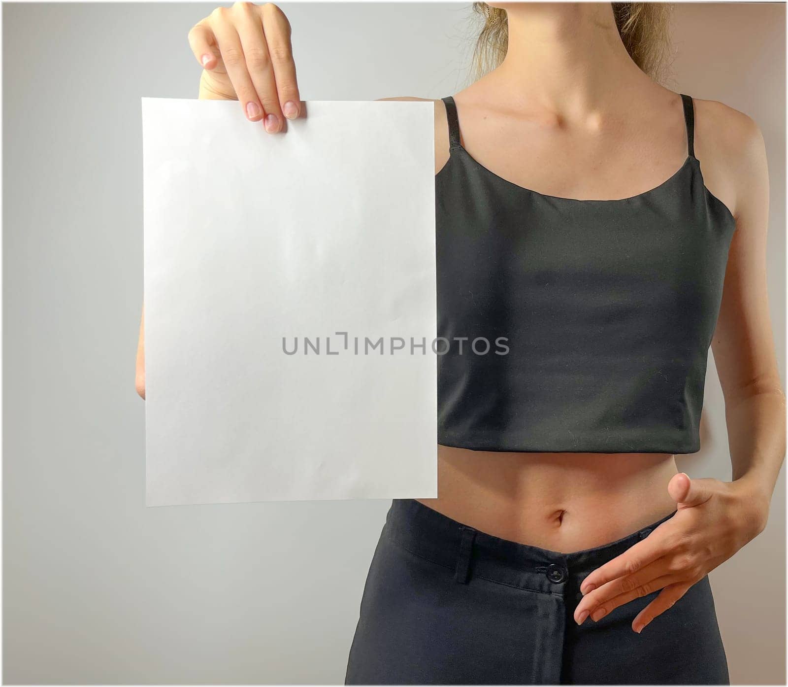 a young girl holds a white sheet of paper in her hands