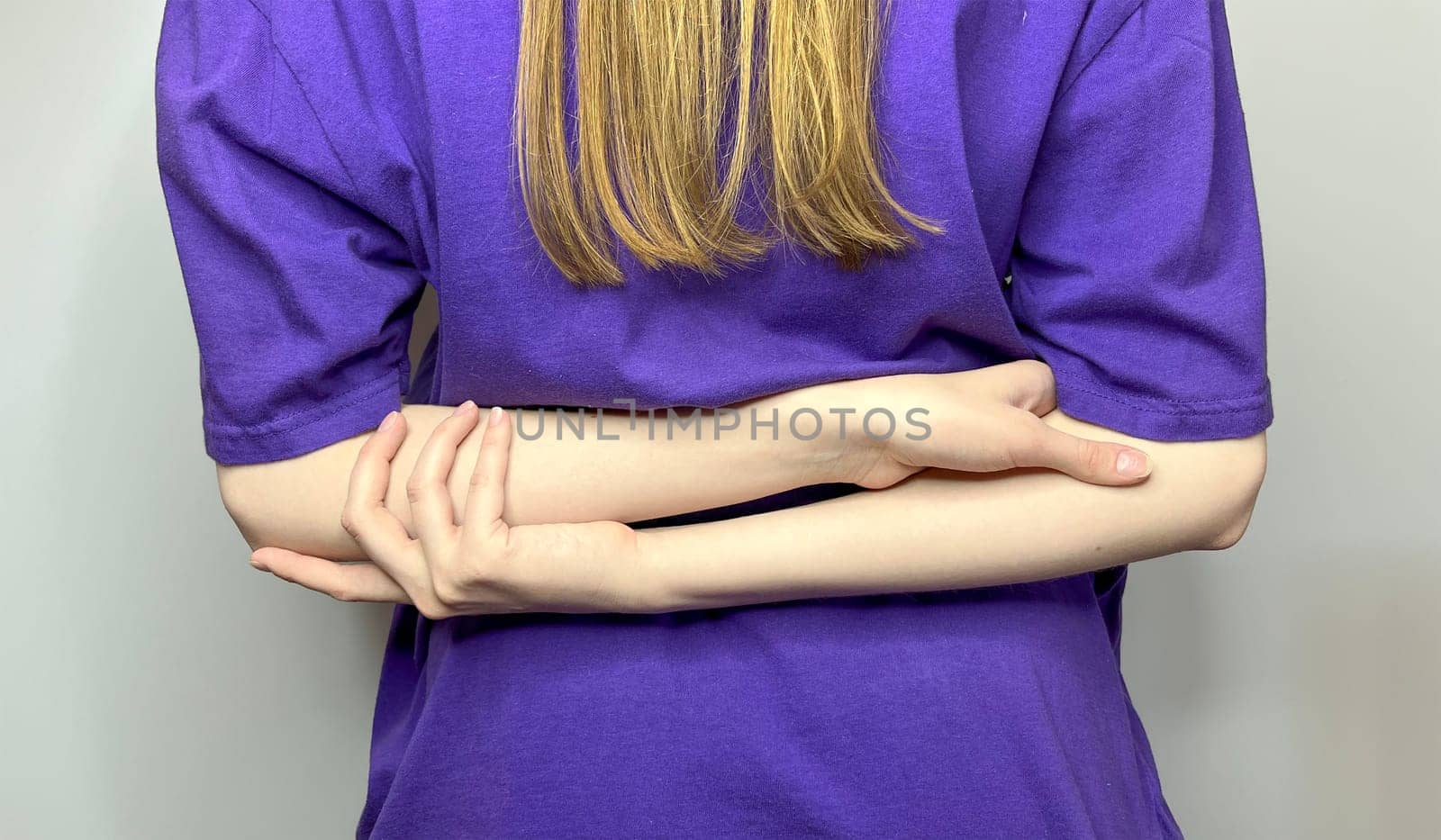 the girl folded her hands behind her back - a closed pose