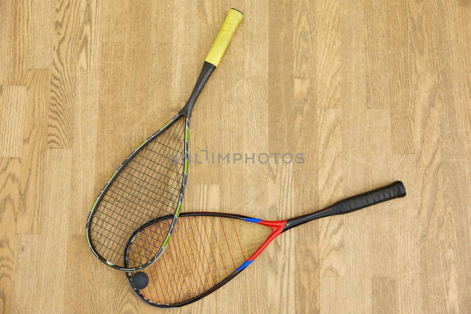 Closeup professional squash game racquet and ball training equipment on court floor top view