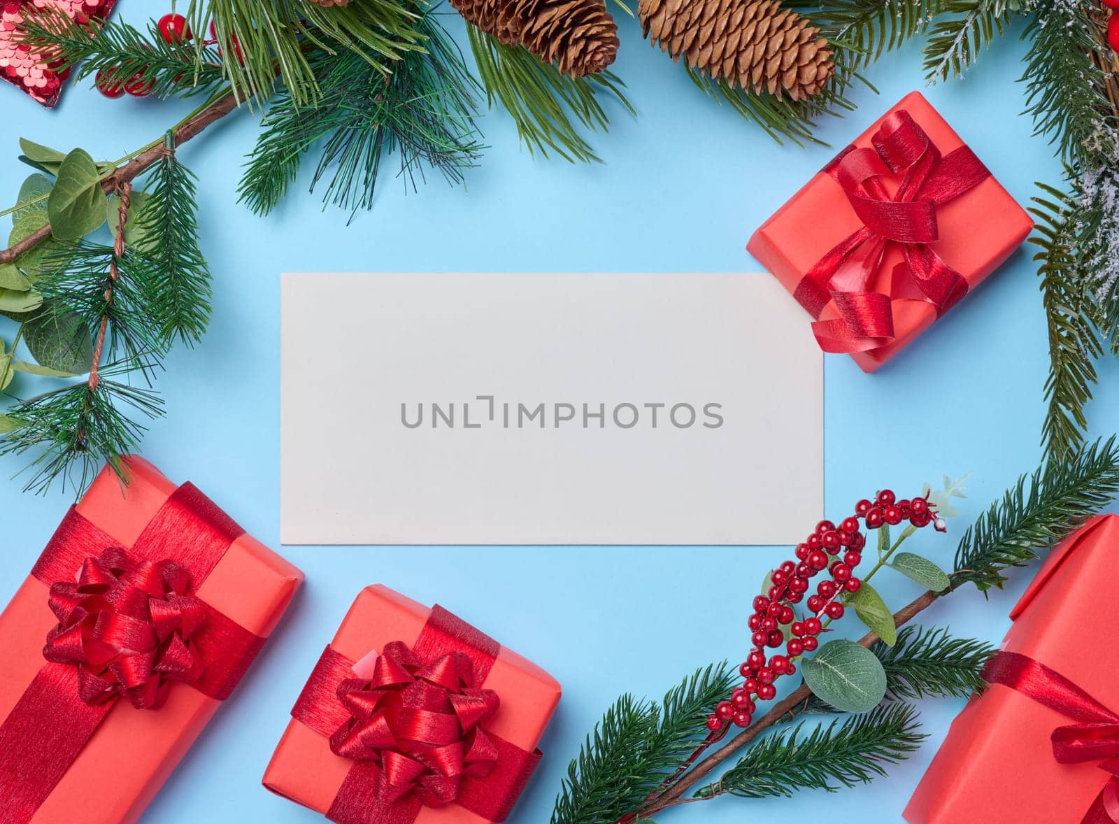 Christmas decor, gifts wrapped in red paper and a letter on a blue background, top view