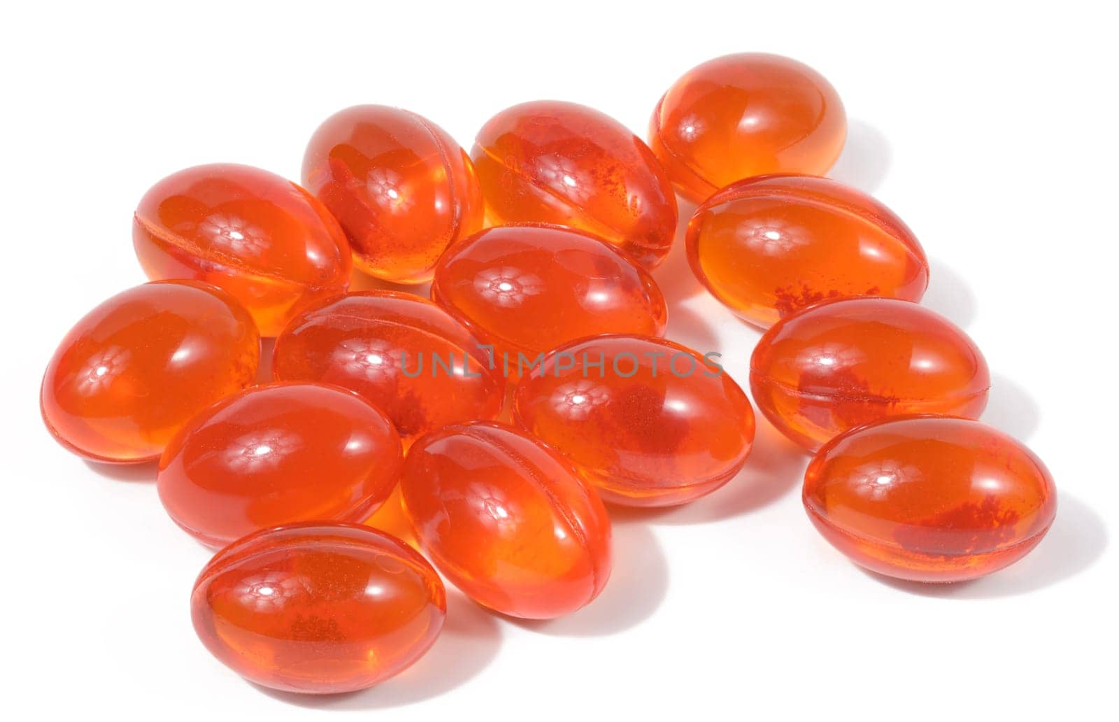 Orange capsules with fish oil on a white background, close up