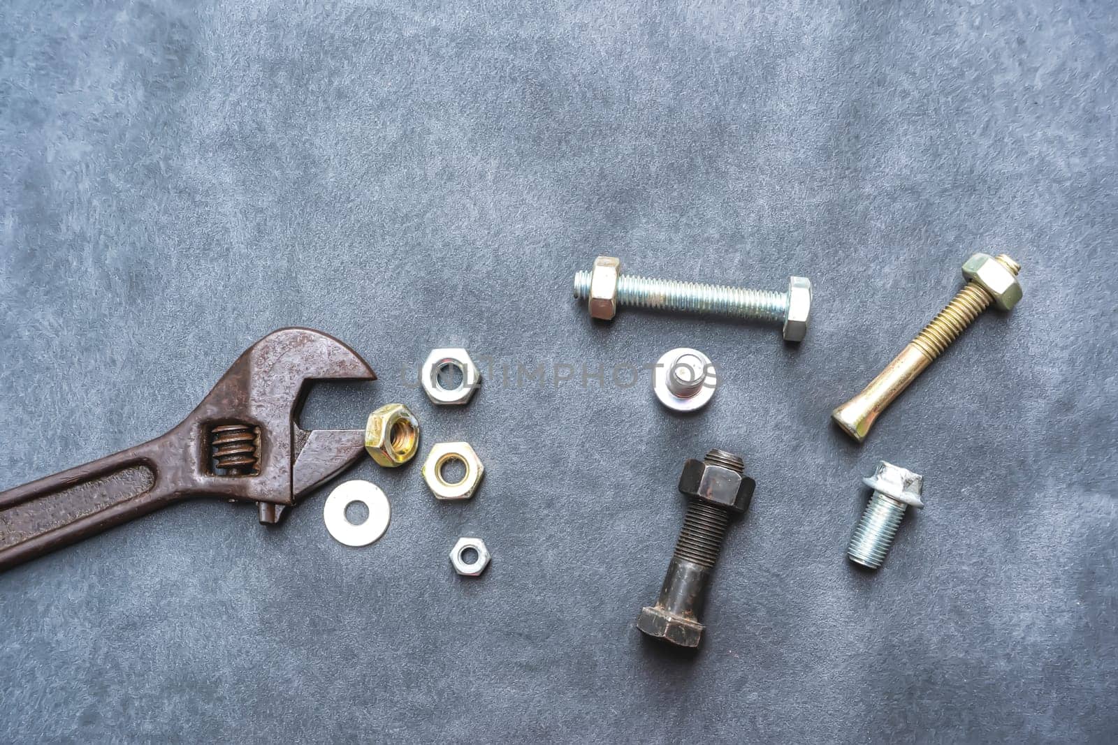 Wrench, hex bolt and hex nut on leather floor.