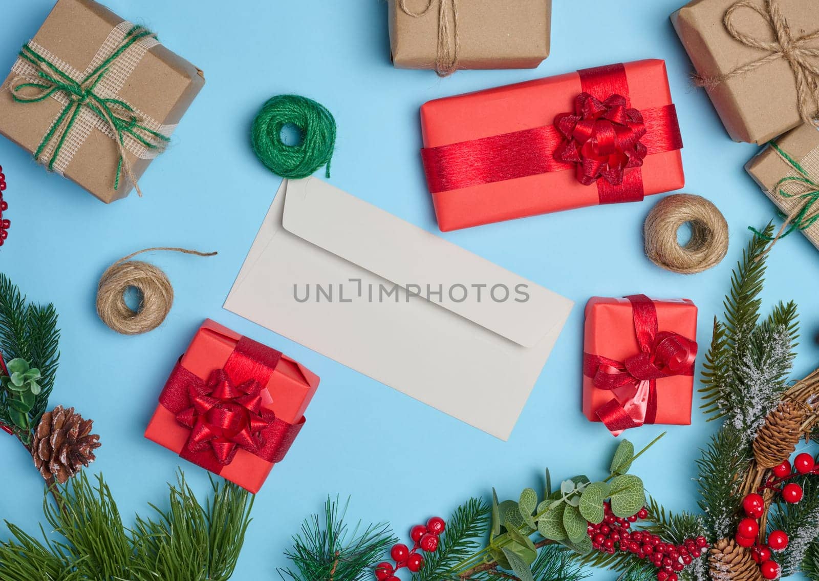 Christmas decor, gifts wrapped in red paper and a letter on a blue background, top view