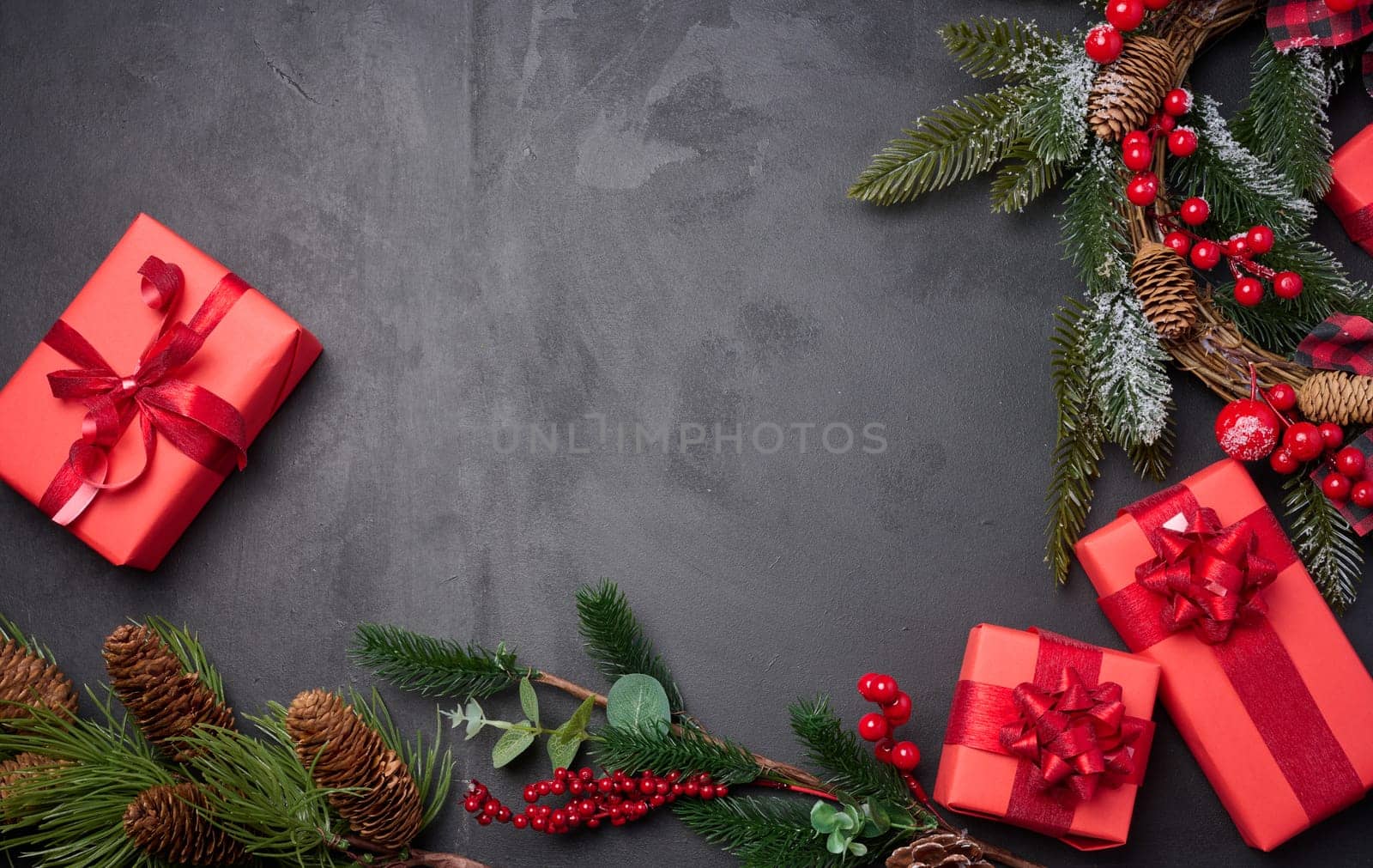 Christmas wreaths, fir branches and gifts on a black background. View from above