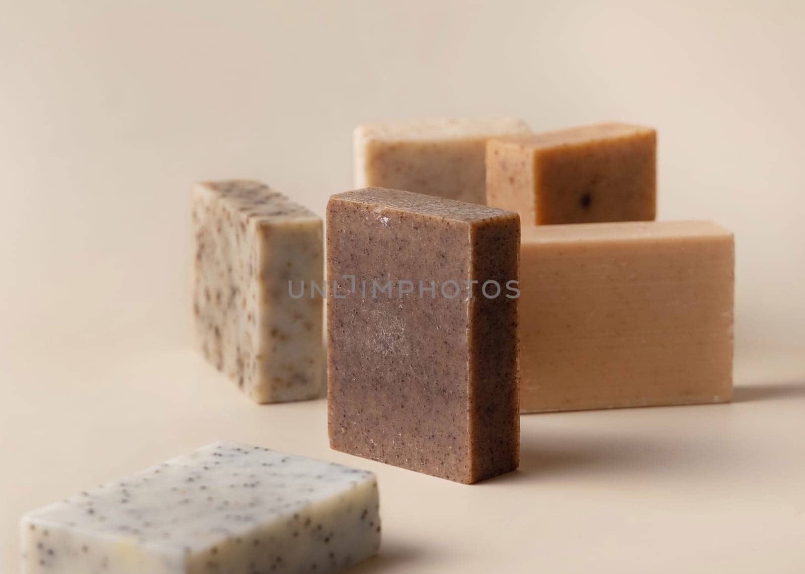 Natural herbal beige and brown handmade soap bars on light beige close up. Hygiene products for Spa and skin care. Using organic handmade sopas in everyday routine
